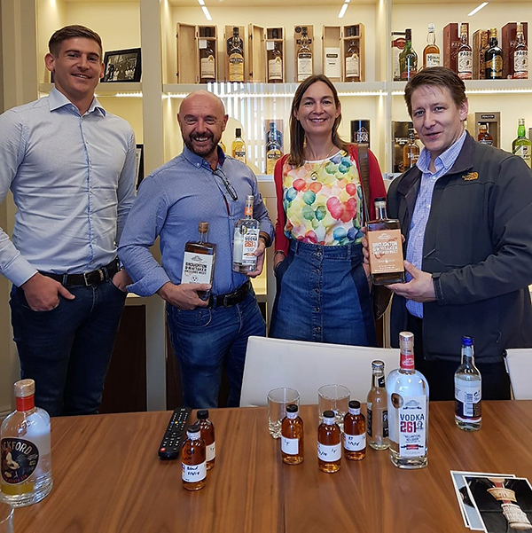 Group of people posing at a tasting for Ghost Coast Distillery