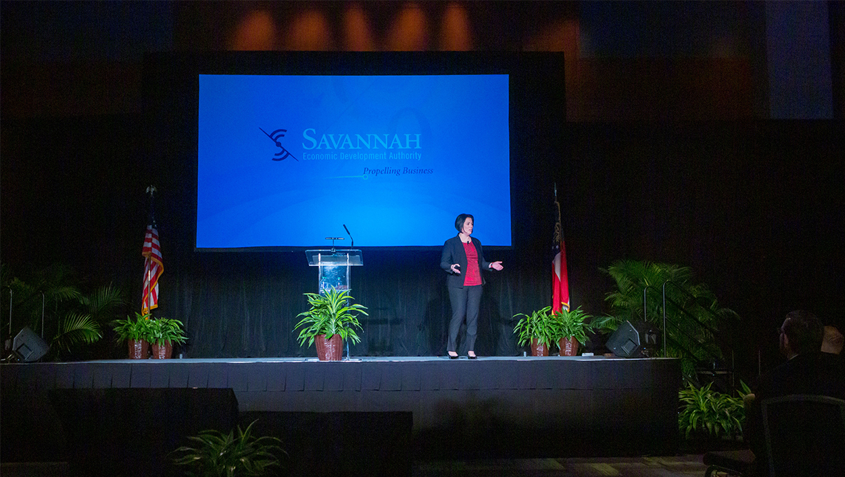 Speaker standing on a stage addressing an audience